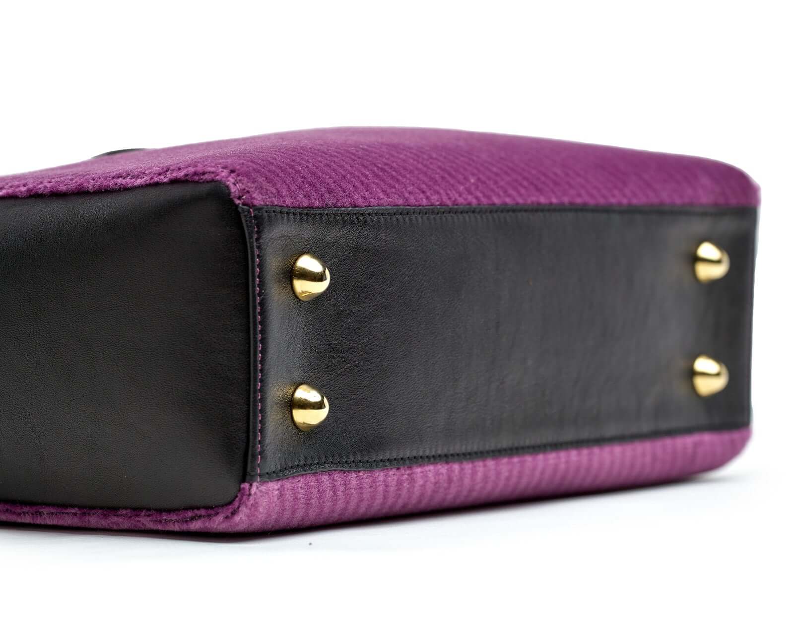 Détail du sac Petit Cabas SLP en cuir noir et velours violet, mettant en avant les boutons dorés.