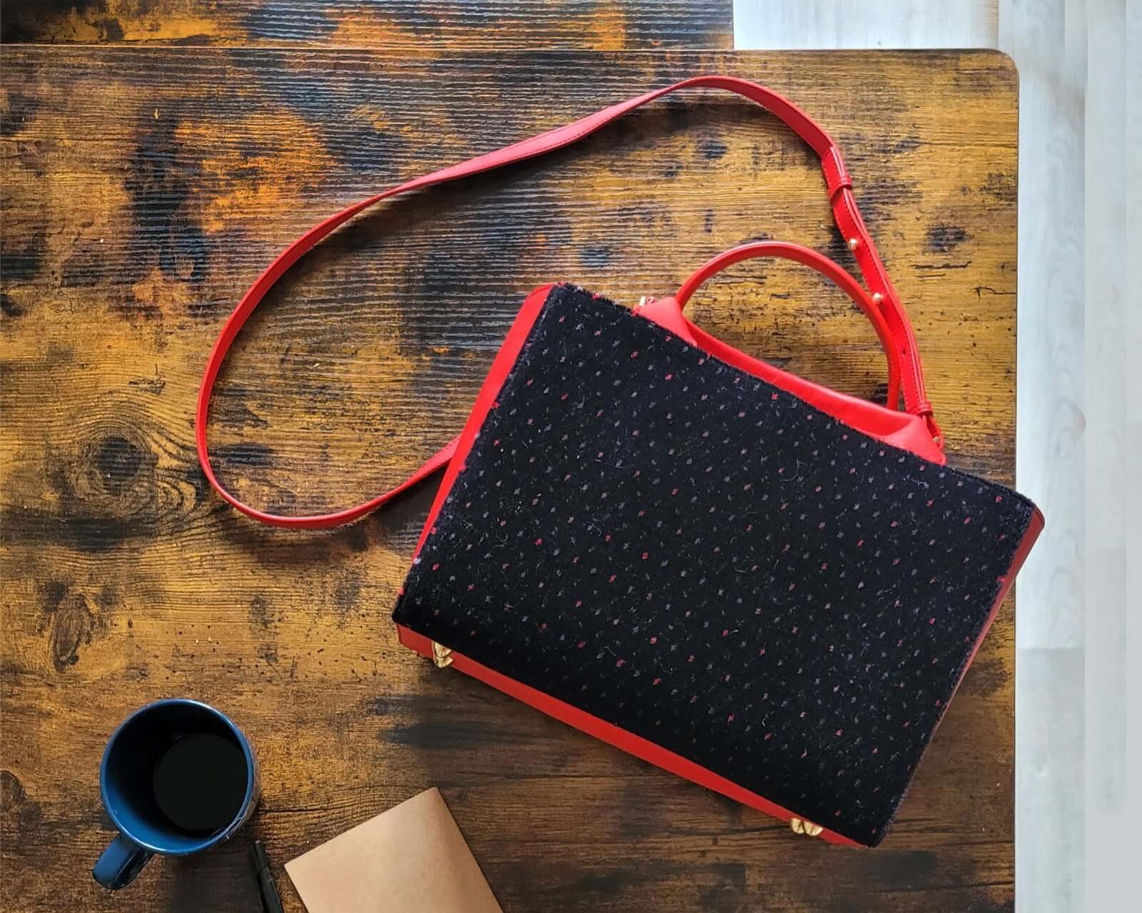 sac Petit Cabas SLP en cuir et velours de laine sur une table en bois avec une tasse de café.